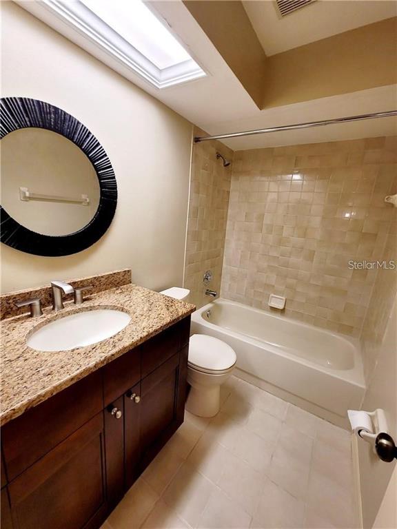 2163 Elm Street, Unit 803 Dunedin, FL 34698 - Photo 12 of 15 a bathroom with a granite countertop sink mirror vanity and a bathtub