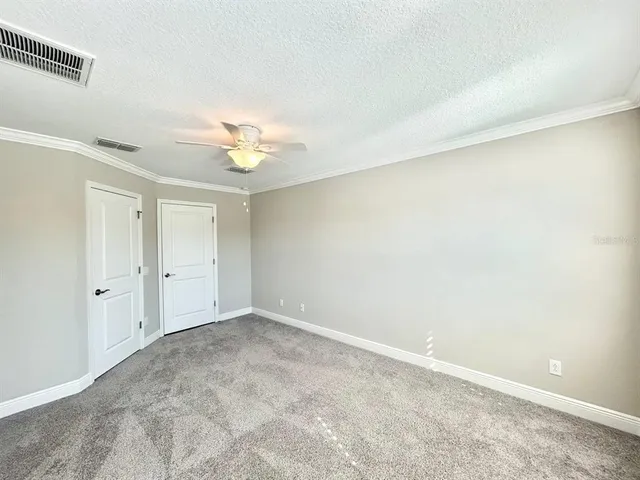 an empty room with a ceiling fan and a window
