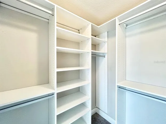 a view of walk in closet with empty racks