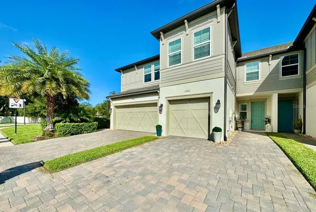 a view of a house with a yard and potted plants