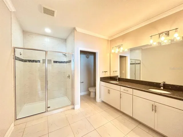 a spacious bathroom with a granite countertop sink mirror and shower