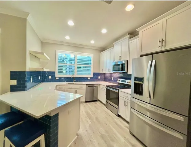 a kitchen with stainless steel appliances a refrigerator sink and stove