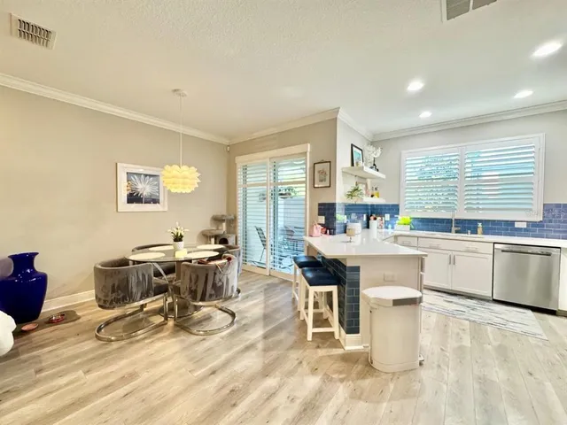 a kitchen with a dining table chairs and large window