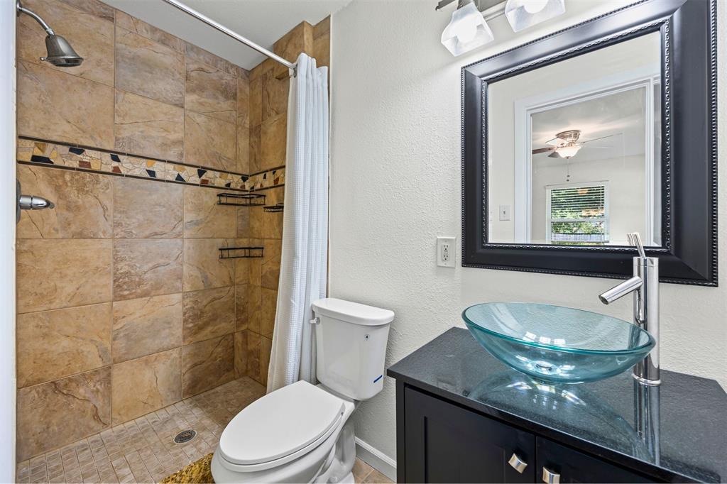 1630 Loree Drive Dallas, TX 75228 - Photo 11 of 20 a bathroom with a granite countertop sink toilet a mirror and shower