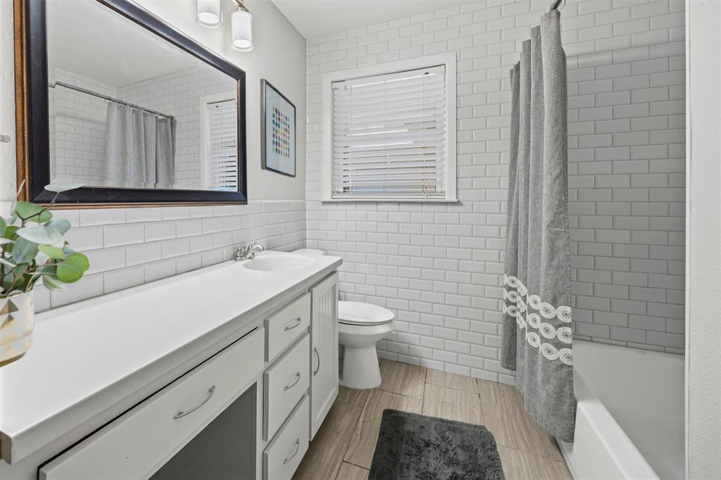 1630 Loree Drive Dallas, TX 75228 - Photo 13 of 20 a bathroom with a sink a toilet and mirror