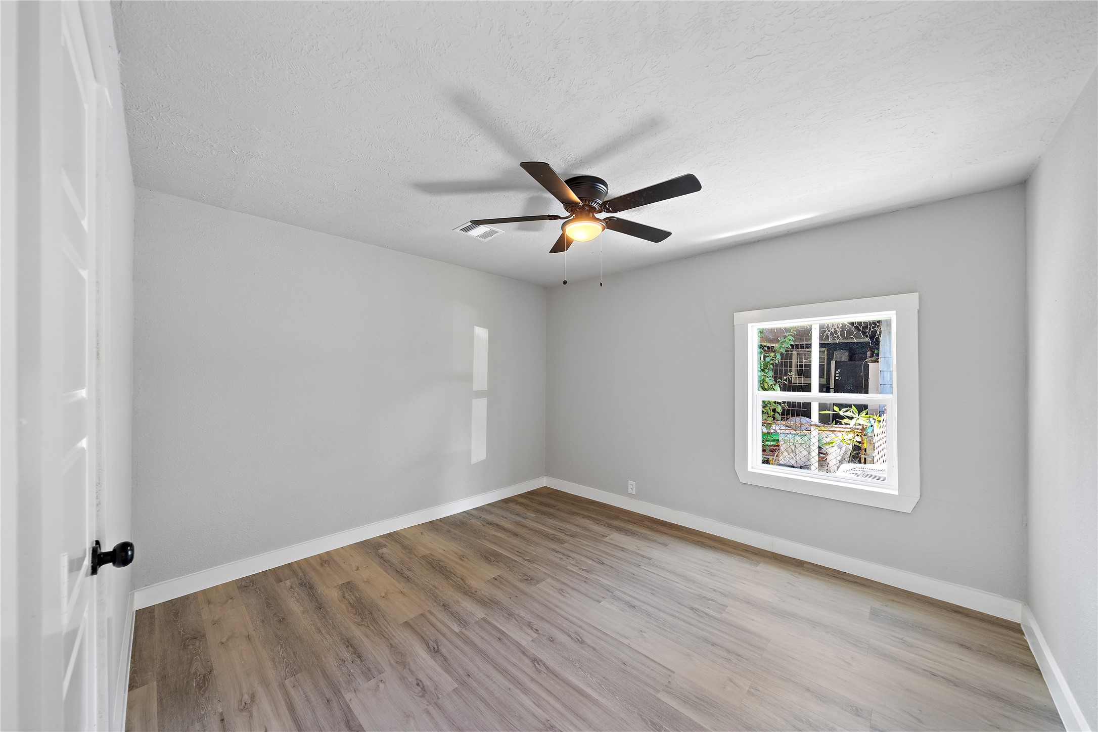1004 West Harris Avenue Pasadena, TX 77506 - Photo 11 of 16 an empty room with wooden floor and windows