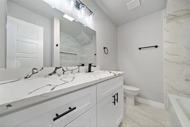 a bathroom with a double vanity sink toilet and a mirror
