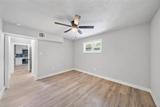 a view of empty room with wooden floor