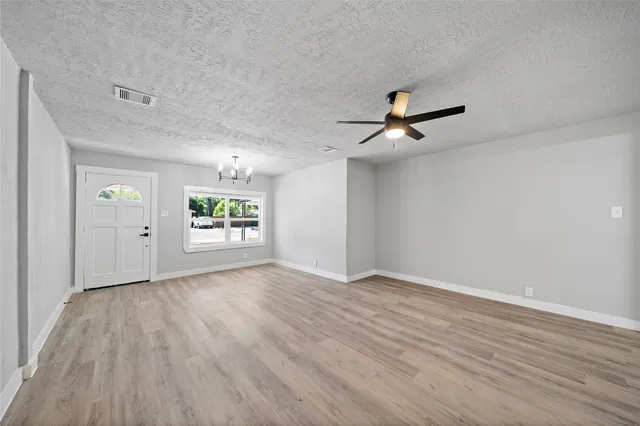 an empty room with window and wooden floor