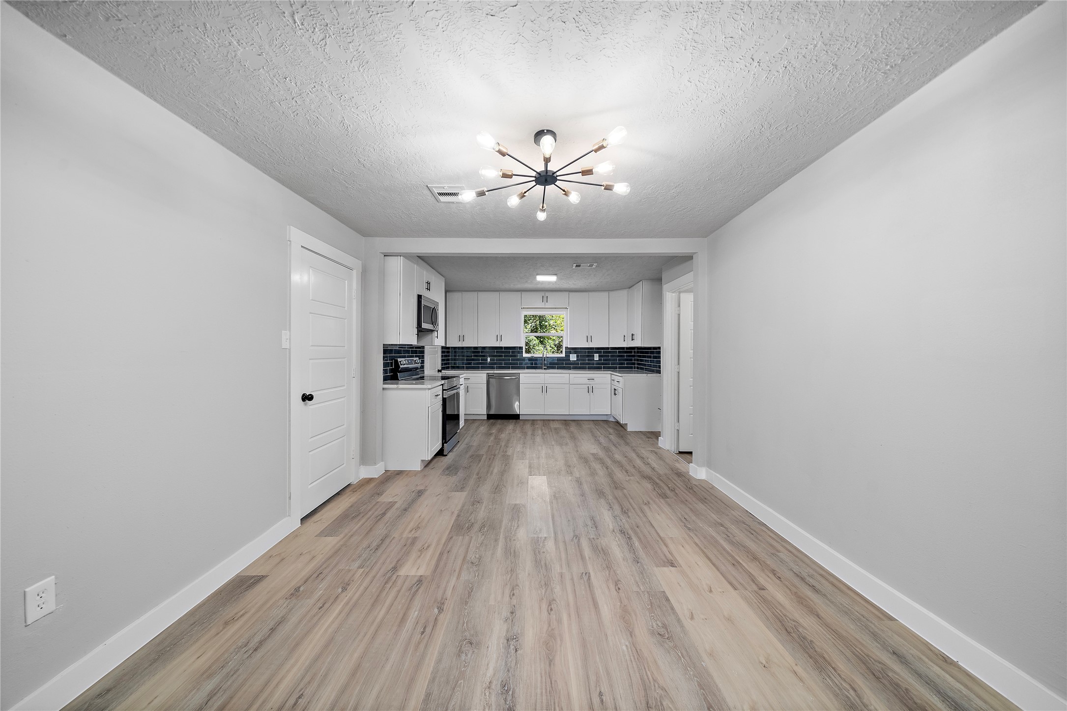 1004 West Harris Avenue Pasadena, TX 77506 - Photo 4 of 16 a view of a kitchen with a sink a refrigerator a ceiling fan and wooden floor