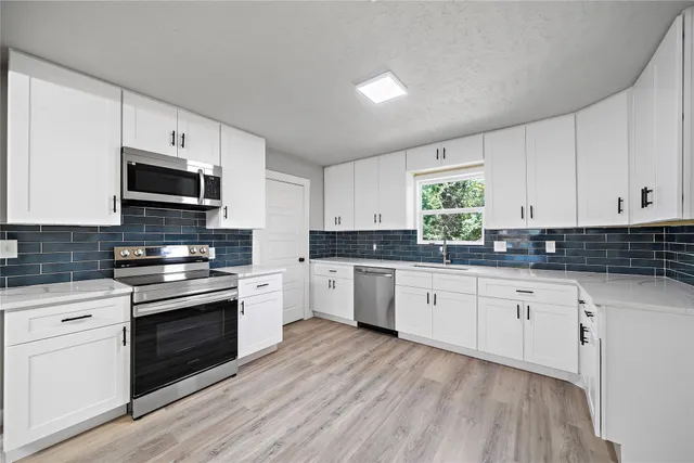 a kitchen with granite countertop white cabinets and white appliances