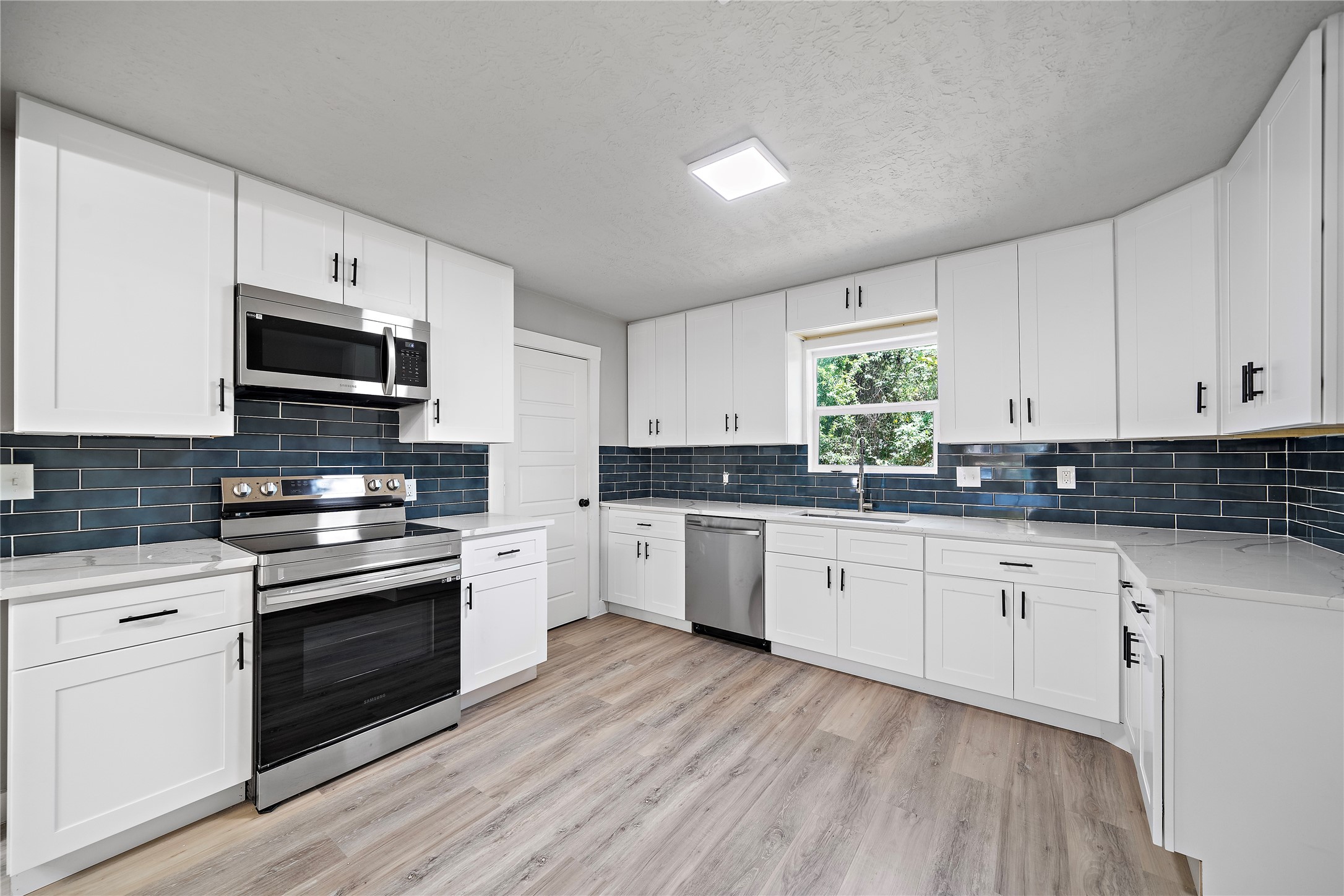 1004 West Harris Avenue Pasadena, TX 77506 - Photo 7 of 16 a kitchen with granite countertop white cabinets and white appliances