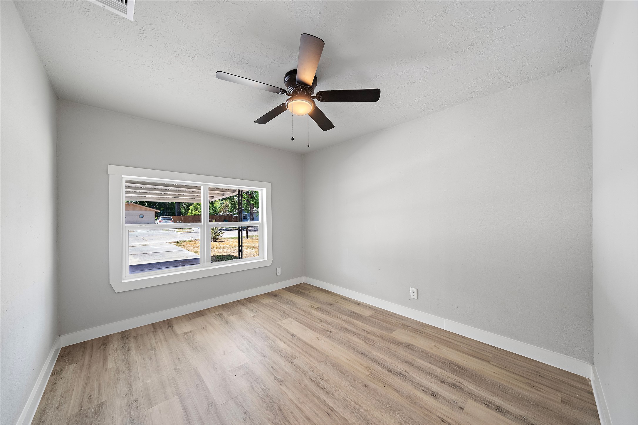 1004 West Harris Avenue Pasadena, TX 77506 - Photo 8 of 16 an empty room with wooden floor ceiling fan and windows