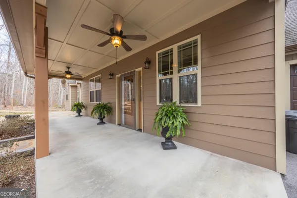 a view of a porch with a table and chairs under an umbrella