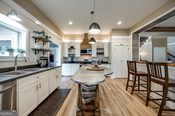 a large kitchen with stainless steel appliances kitchen island granite countertop a sink and cabinets