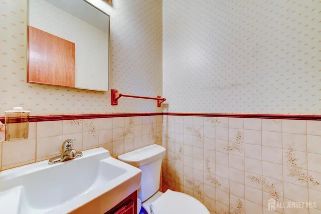 a bathroom with a sink a toilet and mirror