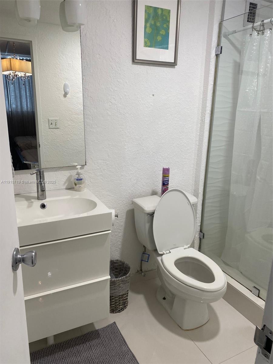 4001 South Ocean Drive, Unit 14F Hollywood, FL 33019 - Photo 14 of 16 a bathroom with a toilet a sink and mirror