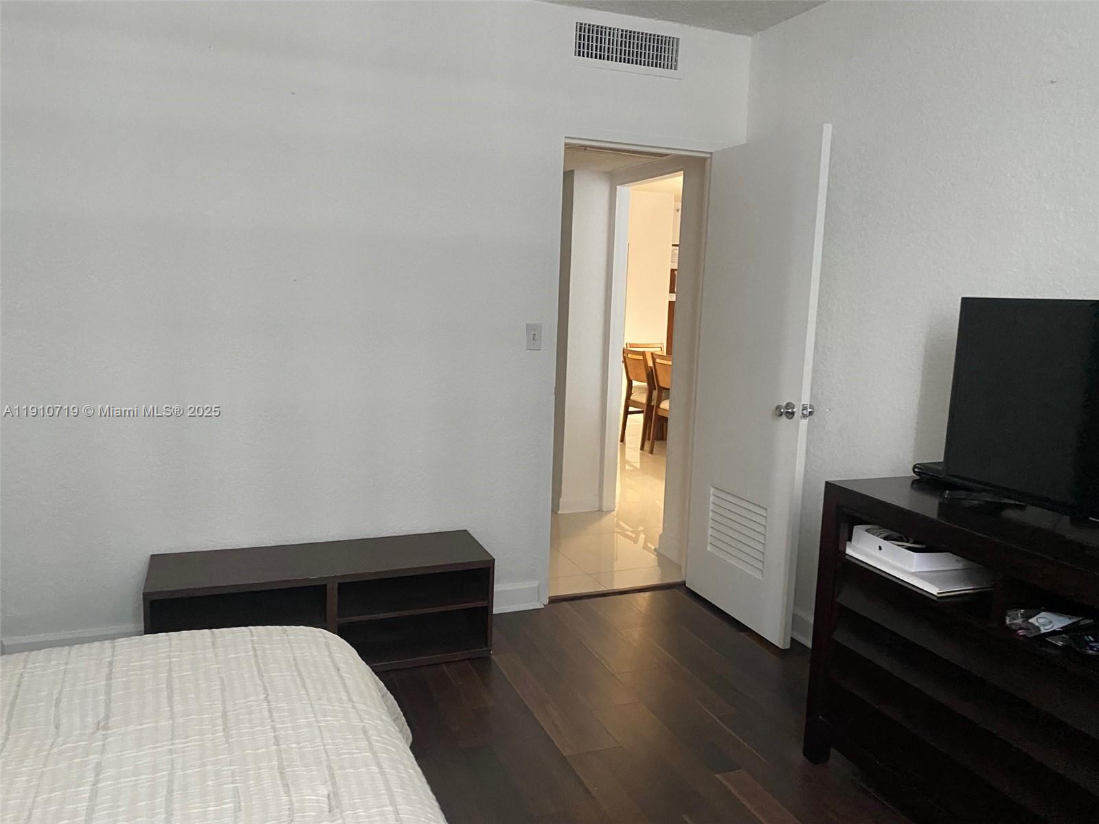 4001 South Ocean Drive, Unit 14F Hollywood, FL 33019 - Photo 16 of 16 a bedroom with a bed and wooden floor