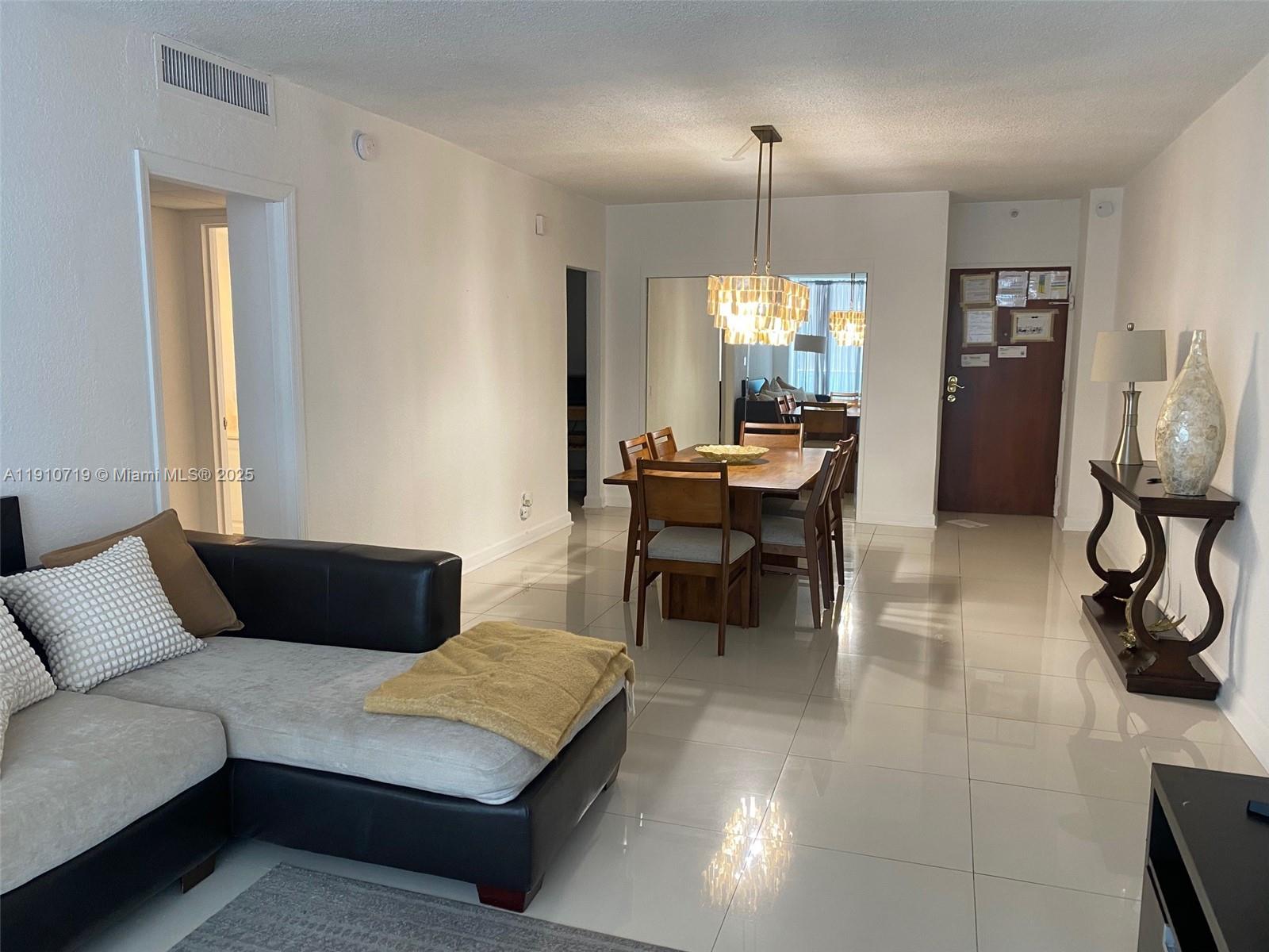 4001 South Ocean Drive, Unit 14F Hollywood, FL 33019 - Photo 7 of 16 a living room with furniture and a chandelier
