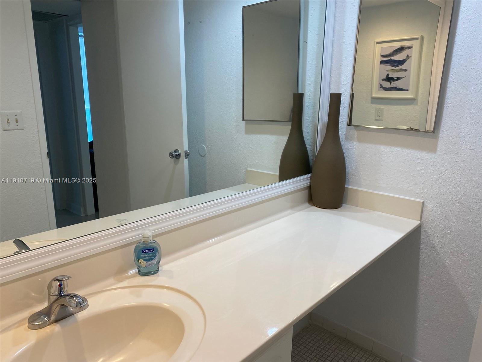 4001 South Ocean Drive, Unit 14F Hollywood, FL 33019 - Photo 8 of 16 a bathroom with a sink and a mirror