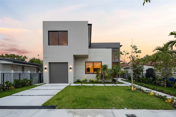 a front view of a house with a garden and yard