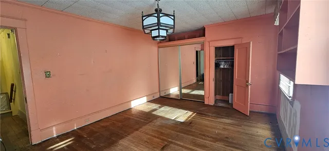 a view of a hallway with wooden floor and a chandelier