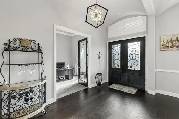 a view of a hallway with wooden floor and entryway