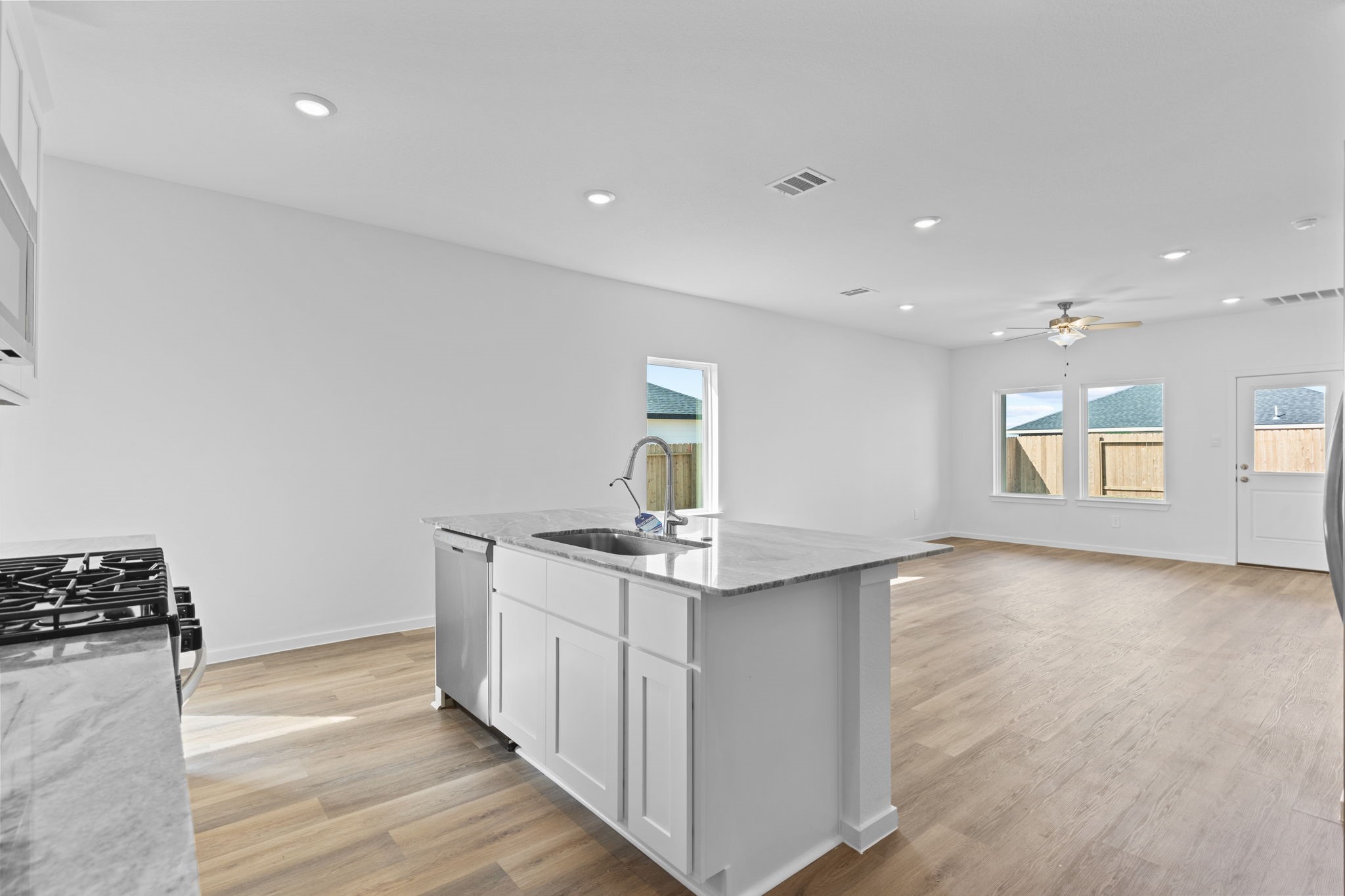 9019 Rose Water Iowa Colony, TX 77583 - Photo 12 of 44 a kitchen with stainless steel appliances granite countertop a sink stove and wooden floor