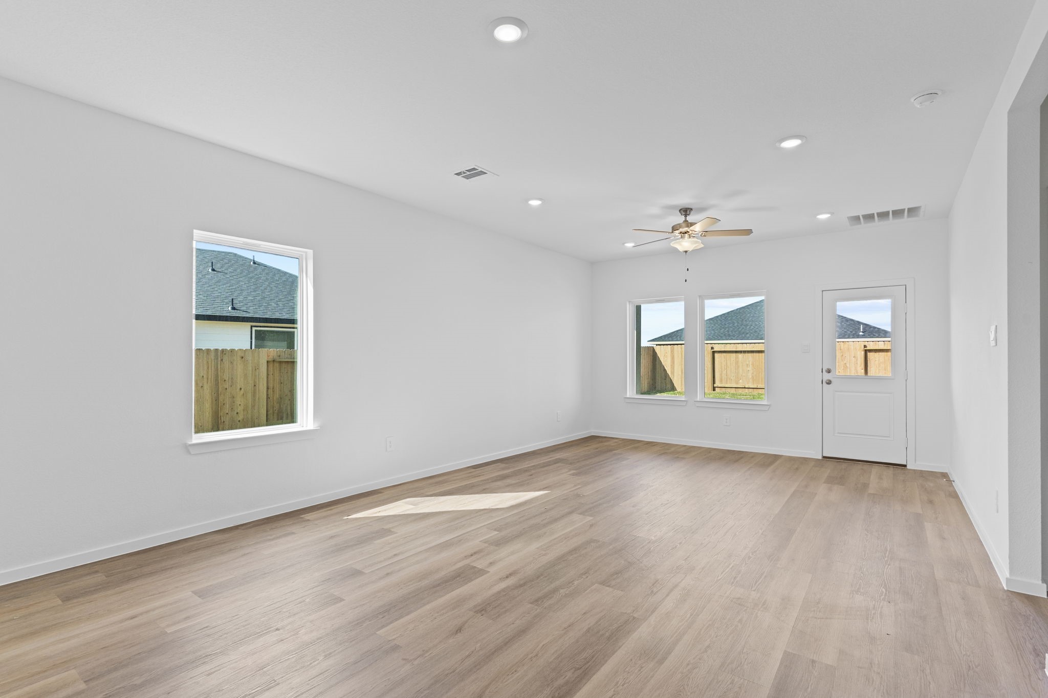 9019 Rose Water Iowa Colony, TX 77583 - Photo 13 of 44 an empty room with wooden floor and windows