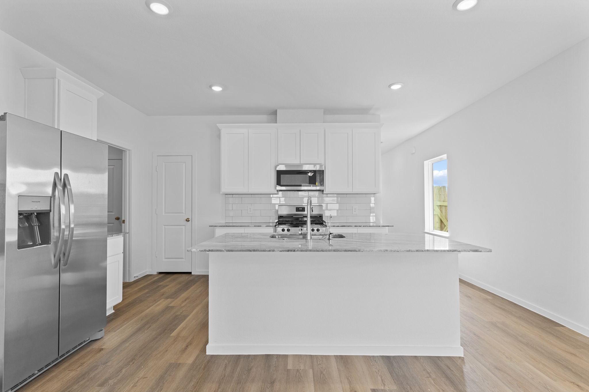 9019 Rose Water Iowa Colony, TX 77583 - Photo 15 of 44 a kitchen with stainless steel appliances granite countertop a sink and a refrigerator