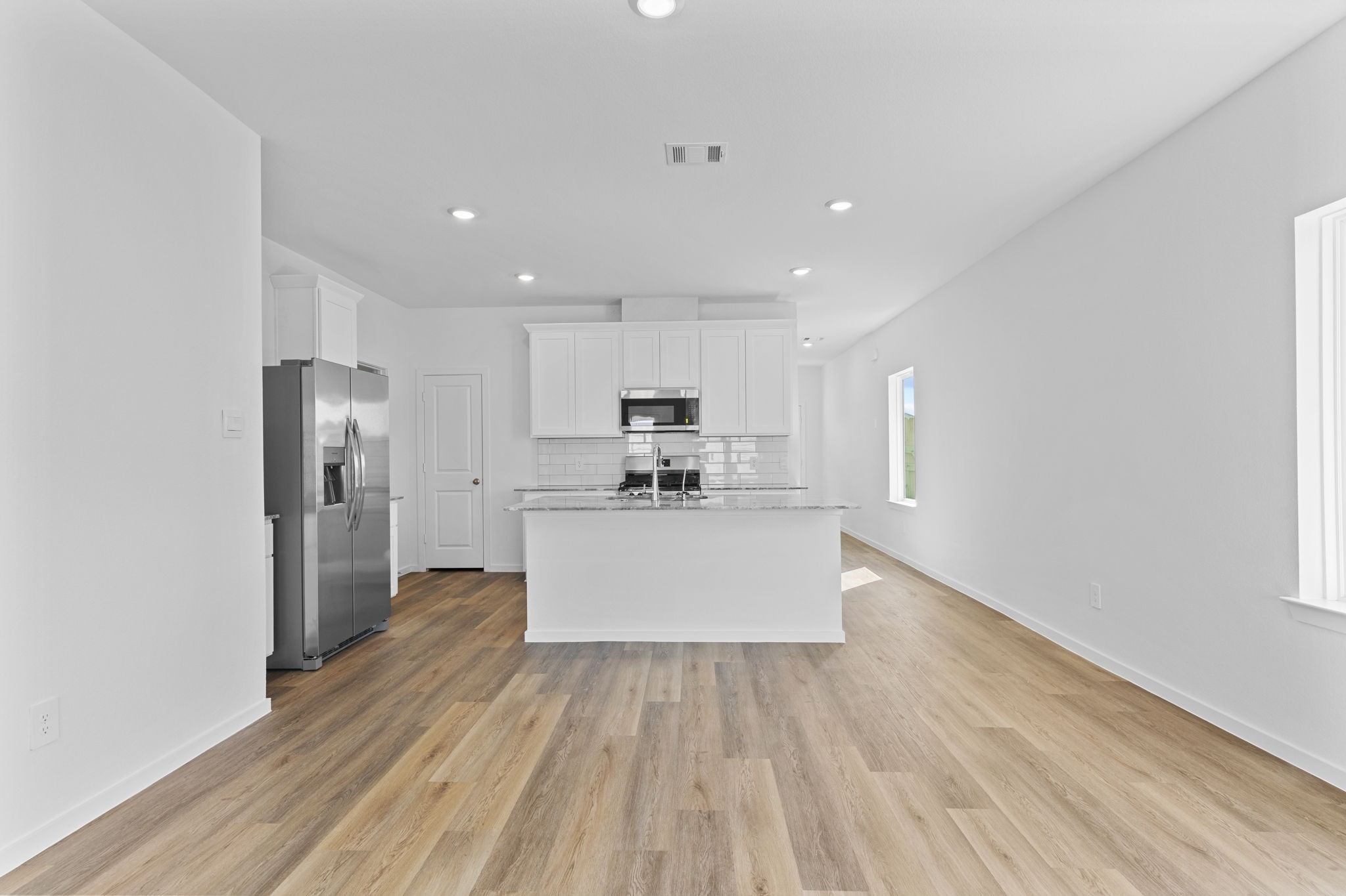 9019 Rose Water Iowa Colony, TX 77583 - Photo 20 of 44 a large kitchen with a center island wooden floor stainless steel appliances and cabinets