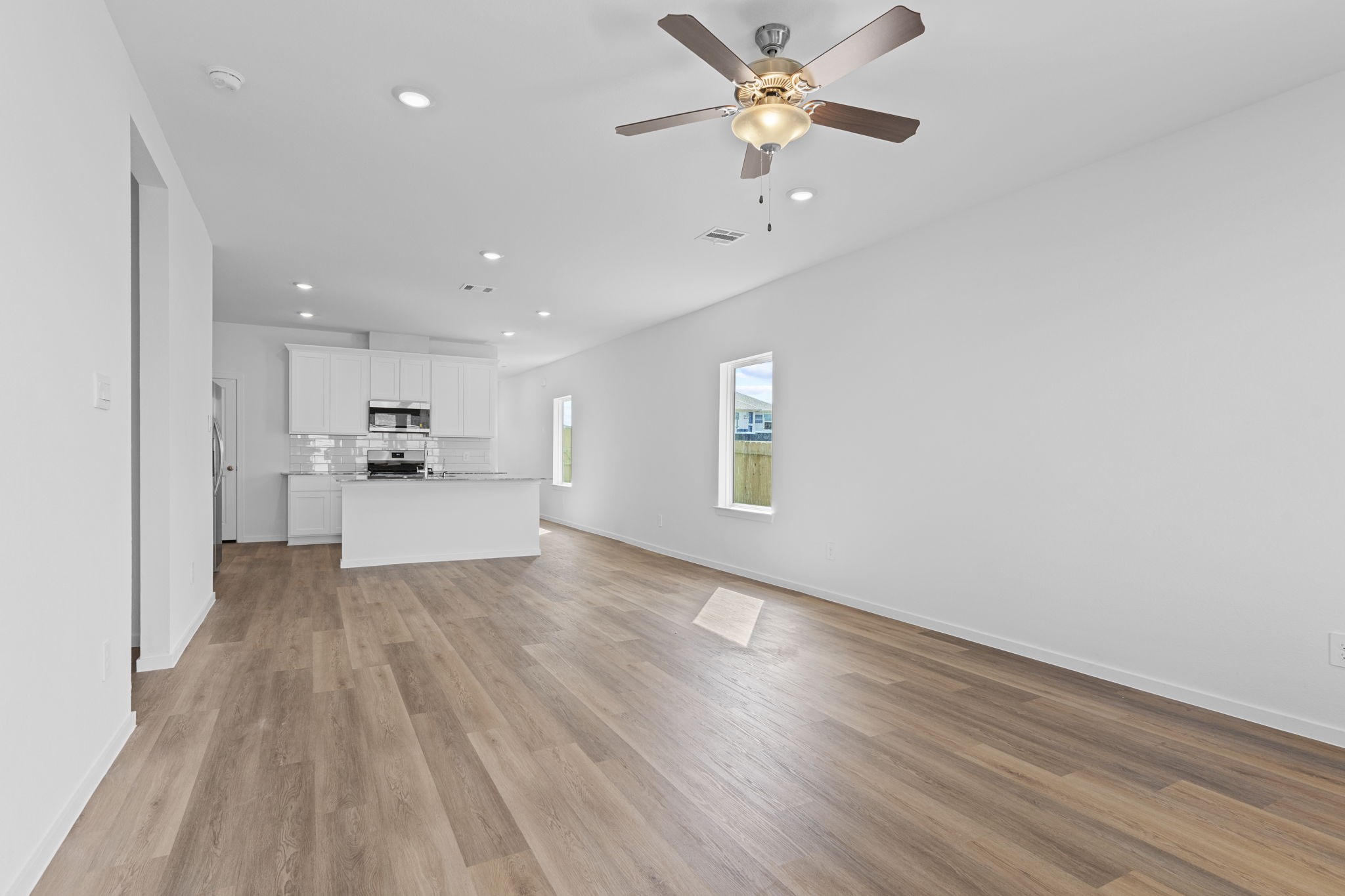 9019 Rose Water Iowa Colony, TX 77583 - Photo 25 of 44 a view of a kitchen with wooden floor and a ceiling fan
