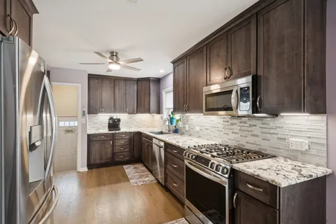 a kitchen with stainless steel appliances granite countertop a sink stove and refrigerator