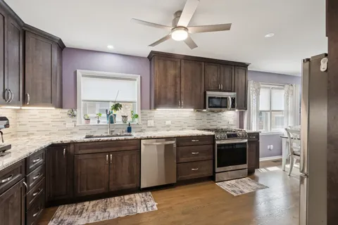 a kitchen with stainless steel appliances granite countertop a sink stove and refrigerator