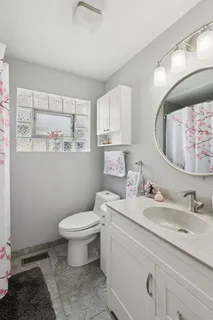 a bathroom with a granite countertop toilet sink and mirror