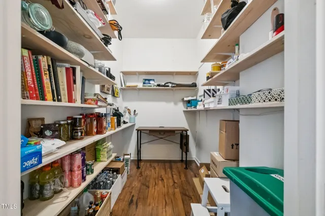 a kitchen with stainless steel appliances granite countertop a stove a refrigerator a kitchen island a sink white cabinets and chairs