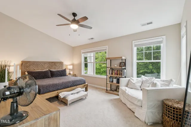a bedroom with a large bed and a chandelier