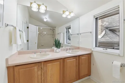 a bathroom with a sink a large mirror and a shower