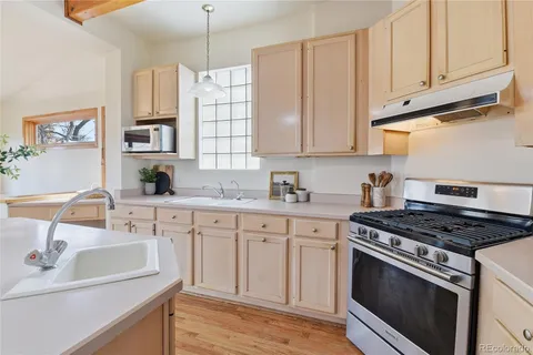 a kitchen with granite countertop a sink stainless steel appliances and cabinets