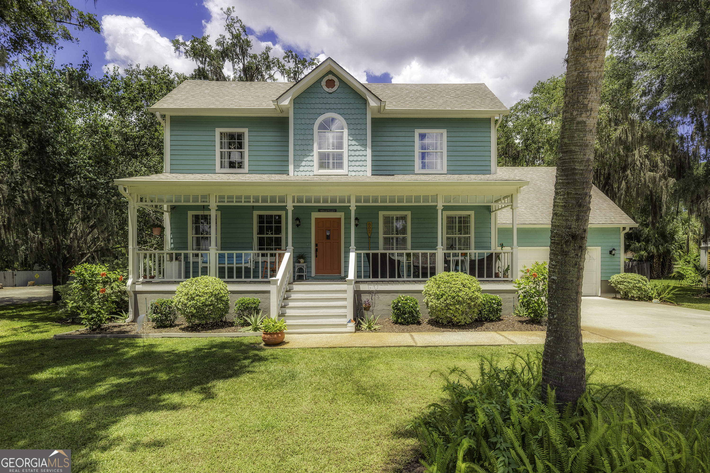 a front view of a house with garden and porch