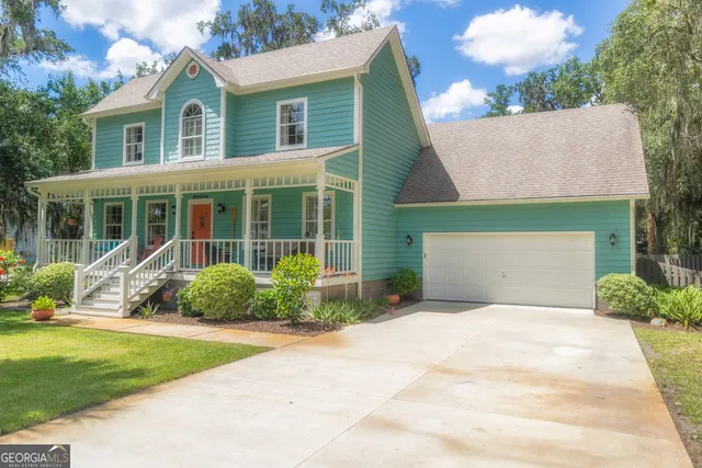a front view of a house with a yard and plants