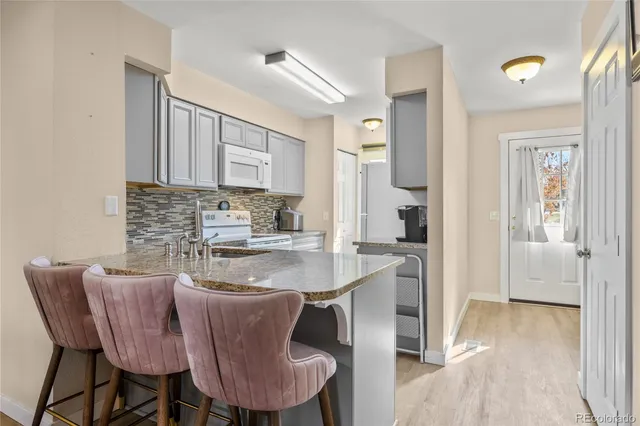 a kitchen with a dining table chairs and cabinets