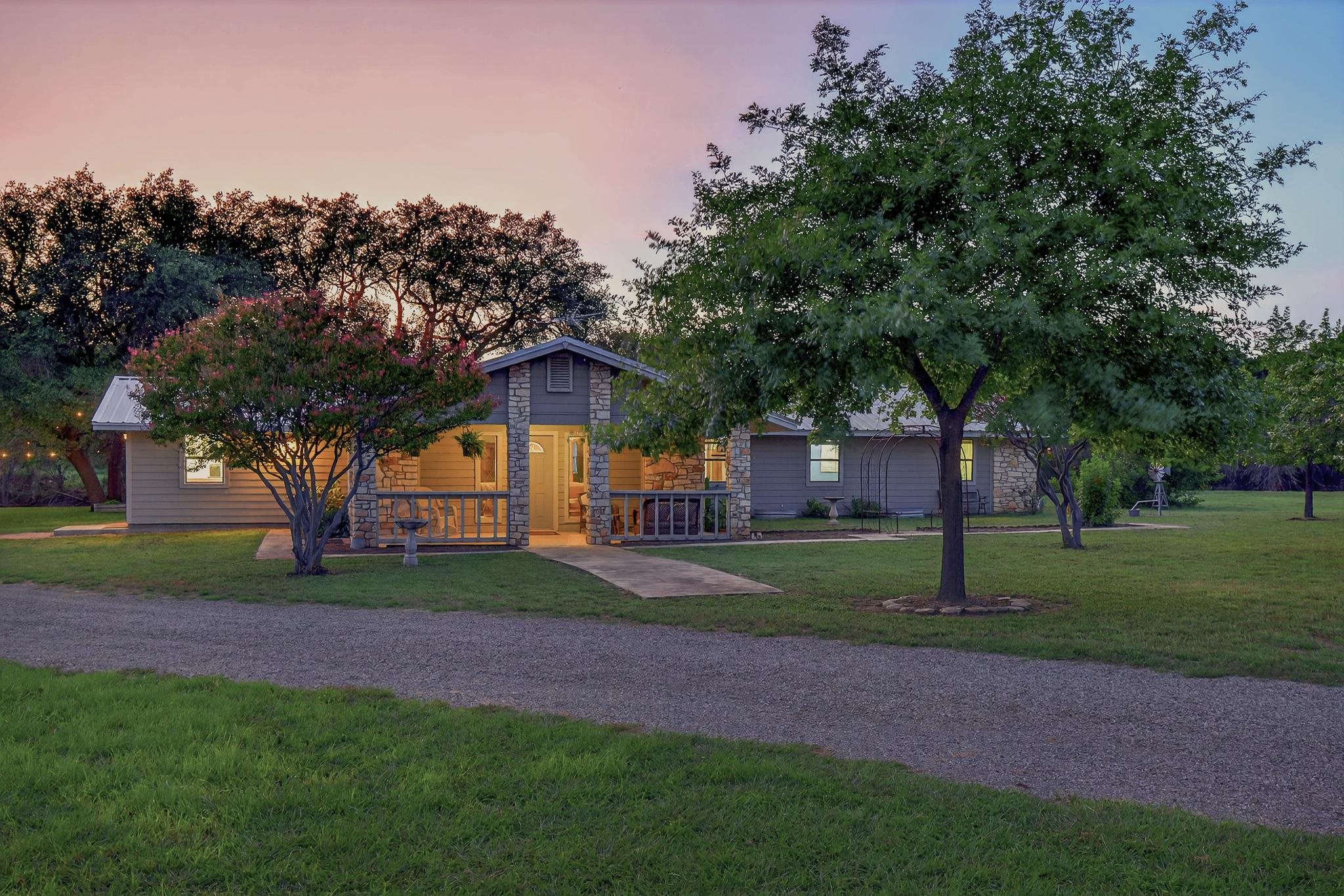 a front view of a house with a yard and trees