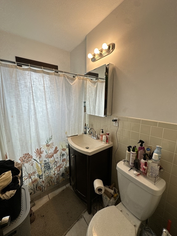 435 Walnut Avenue, Unit 8 Boston, MA 02119 - Photo 10 of 12 a bathroom with a sink toilet and a mirror
