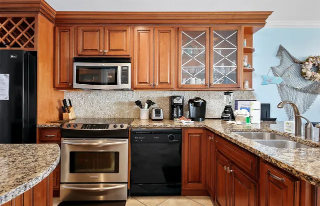 a kitchen with granite countertop a sink stove and microwave