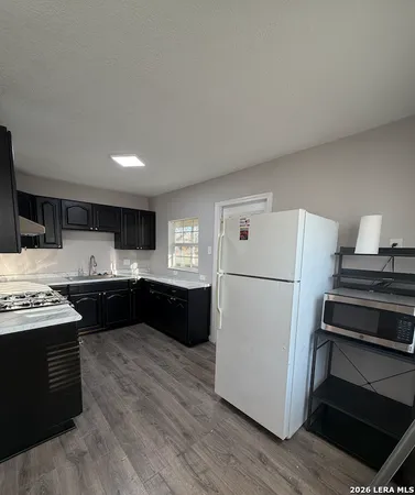 a kitchen with a refrigerator and a stove top oven