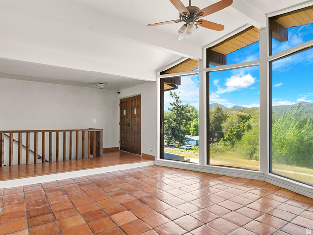 15680 North Beaver Dam Road Collinston, UT 84306 - Photo 5 of 49 Expansive window wall with natural surroundings, terracotta floor tiling, vaulted ceilings, a ceiling fan, and a solid wood entry door