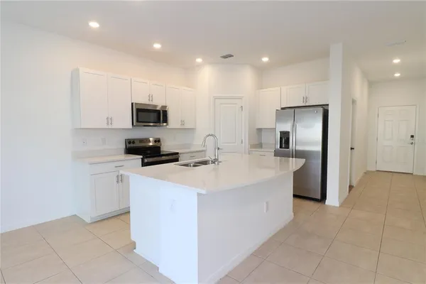 a kitchen with stainless steel appliances a refrigerator sink and microwave