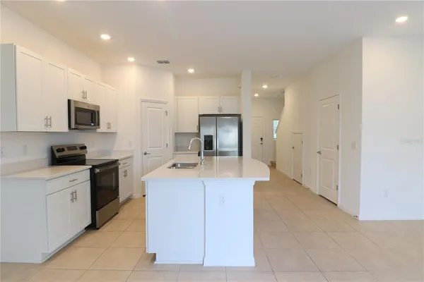 a large kitchen with stainless steel appliances granite countertop a sink and cabinets