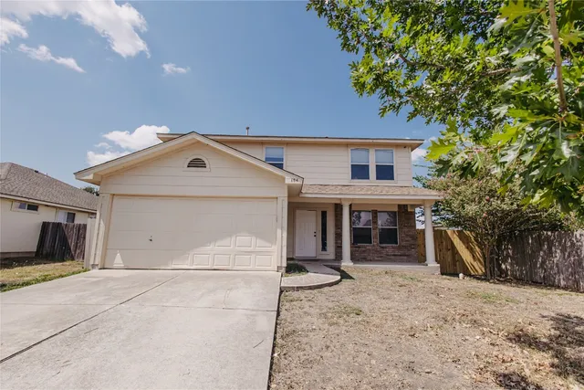 a view of a house with a yard and large tree
